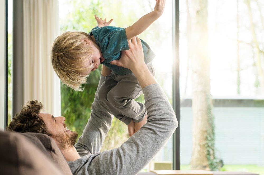 En pappa håller upp sitt barn